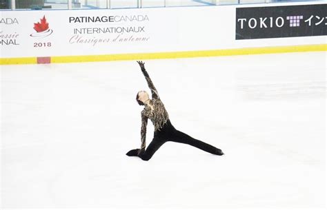 A Woman Is Performing On An Ice Rink With Her Arms In The Air And One