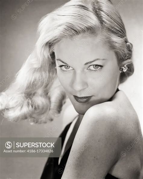 S SEXY SULTRY ATTRACTIVE WOMAN BLONDE HAIR TOSSED BLOWN TO THE SIDE LOOKING AT CAMERA OVER