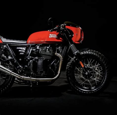 A Red And Black Motorcycle Parked In The Dark