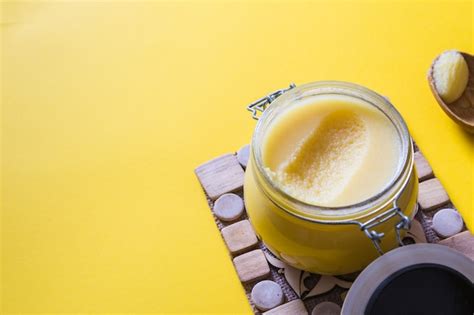 Premium Photo Ghee Or Clarified Butter In Jar And Wooden Spoon On