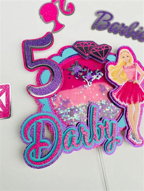 A Birthday Cake Topper With The Number Five And Barbie Doll On It