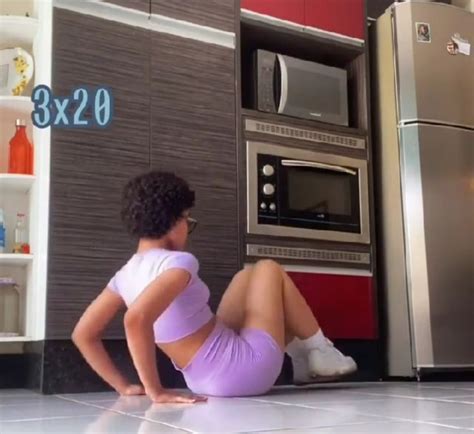 A Woman Is Sitting On The Floor In Front Of An Oven And Microwave