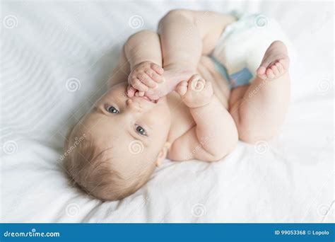 Cute Happy 7 Month Baby Girl In Diaper Lying And Playing Stock Photo