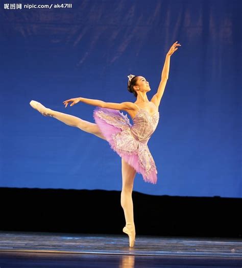 A Ballerina In Pink Tutu And White Dress Doing A Ballet Move On Stage