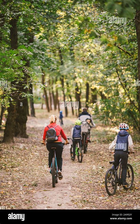 Les parents et les enfants à vélo sur piste forestière Jeune famille à