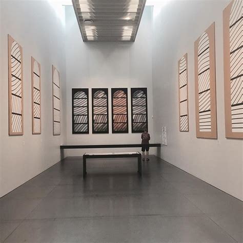 An Empty Room With Four Windows And A Bench In Front Of The Two Wall