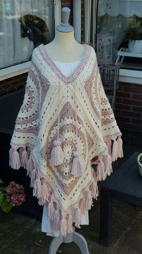 A Crocheted Ponchy With Tassels On A Mannequin