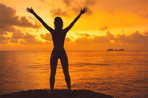 Premium Photo Womans Silhouette With Raised Arms Against Calm Sunset