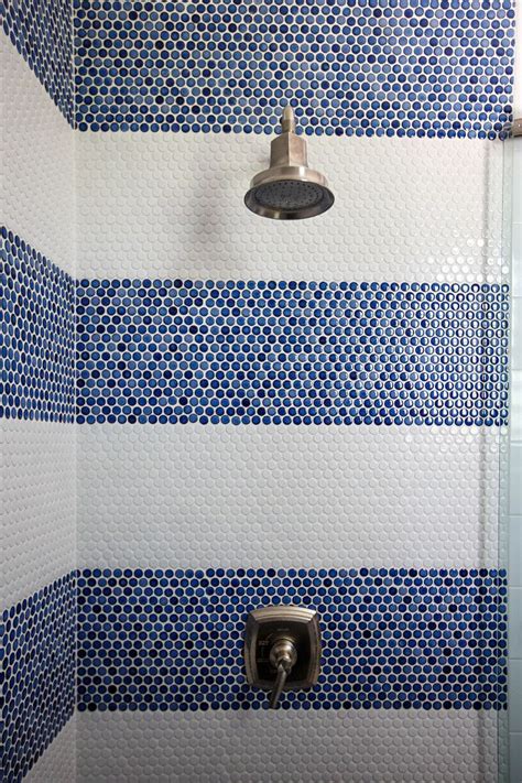 A Shower With Blue And White Tiles On The Wall Next To A Shower Head In