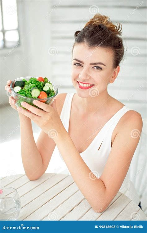 Portrait Of A Young Woman Holding A Fresh Salad Bowl In White Room