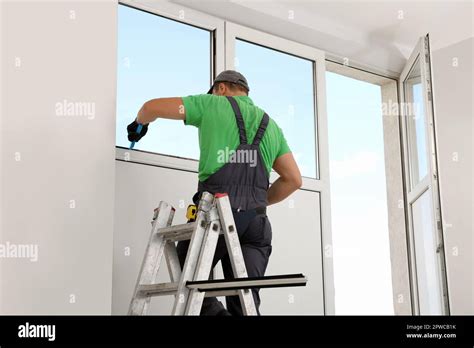 worker  folding ladder installing window indoors stock photo alamy