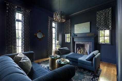 A Living Room With Blue Couches And Curtains On The Window Sill In Front Of A Fireplace