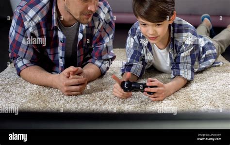 Dad Advising Son How To Operate Video Game Joystick Support And Care