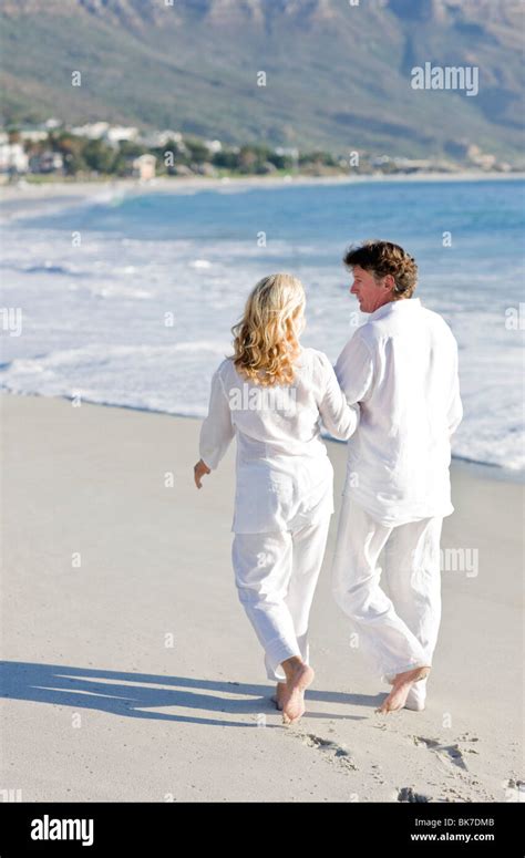 Couple Walking Along A Beach Stock Photo Alamy