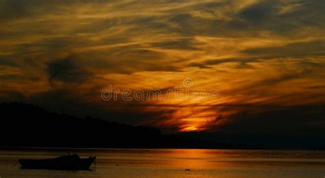 Silhouette of a Boat and Sunset with Dark Colors Stock Image - Image of ...