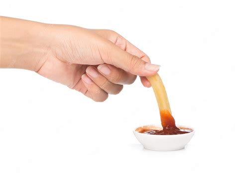 Premium Photo Hand Dip French Fries Chips Into Ketchup Isolated On