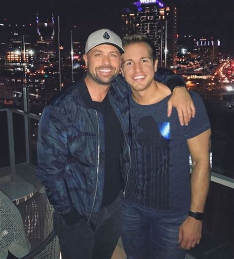 two people standing next to each other in front of a cityscape at night