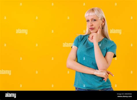Portrait With Pensive Pose Copy Space Blonde Caucasian Girl In Studio On Yellow Background