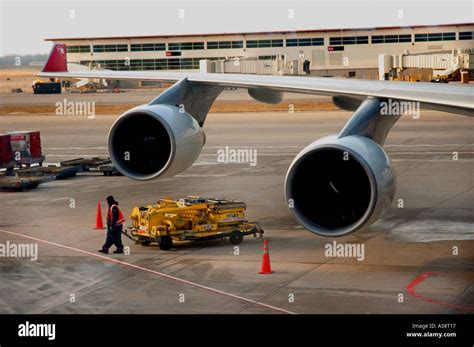 Ground crewman working on airport tarmac Stock Photo - Alamy