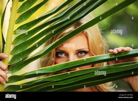 Woman Hiding Behind The Palm Leaves Stock Photo Alamy