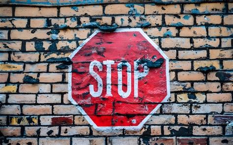 Premium Ai Image A Stop Sign On A Brick Wall That Says Stop