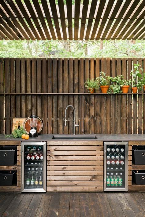 an outdoor kitchen made out of pallets and wooden planks with plants ...