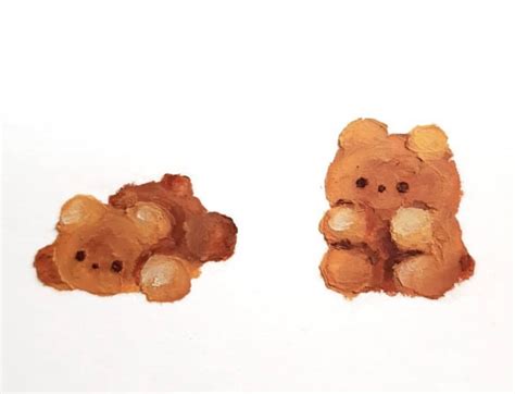 Two Brown Teddy Bears Sitting Next To Each Other On A White Surface