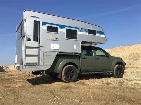 An Off Road Vehicle With A Camper Attached To It