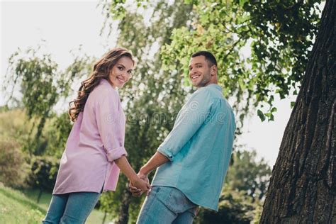 Rear Behind Portrait Of Two Partners Hold Arms Toothy Smile Have Good