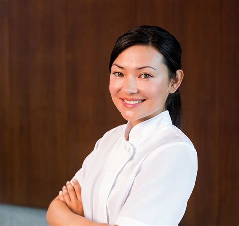 Portrait Of A Confident Female Masseur Standing With Arms Crossed Dm