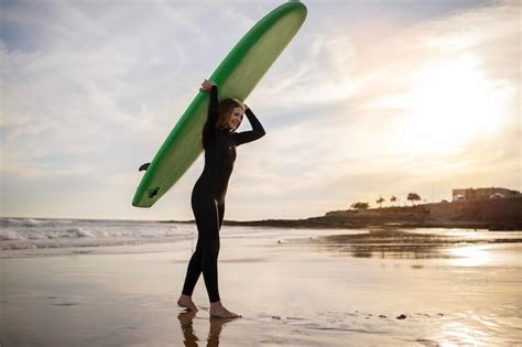 Retrato De Una Joven Surfista Caminando Con Tabla De Surf En La Playa