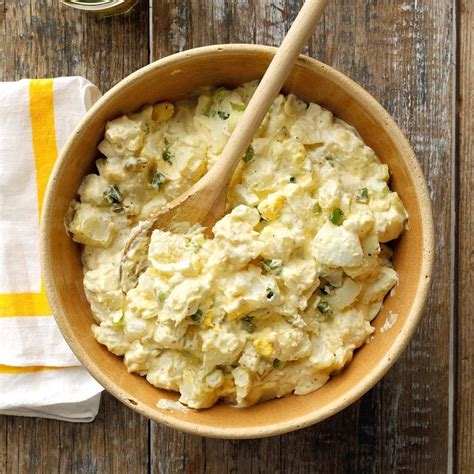 A Wooden Bowl Filled With Mashed Potatoes On Top Of A White And Yellow