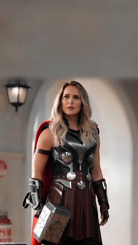 A Woman Dressed Up As Thor From The Avengers Movie Standing In Front Of