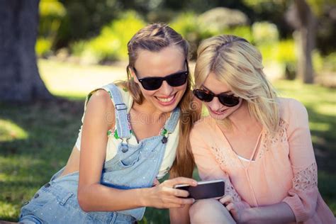 Mulher Que Mostra O Telefone Celular A Seu Amigo Foto De Stock Imagem