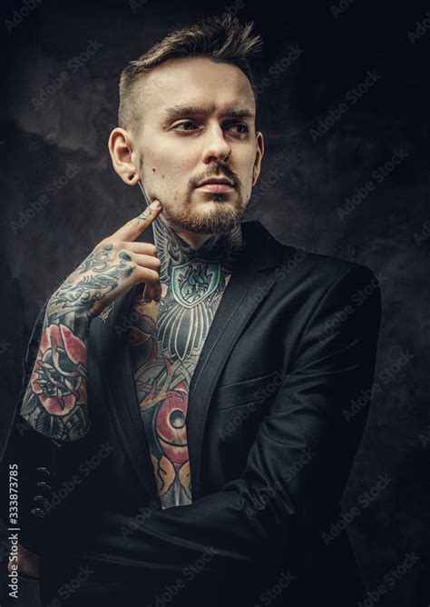 Alternative Looking Tattoo Artist Posing On A Dark Background Wearing A