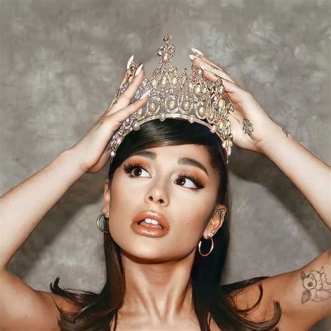 A Woman Wearing A Tiara And Holding Her Hands Up To Her Head While Posing For The Camera