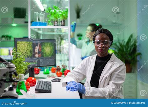 Portrait Of Biologist Woman Putting Medical Glasses Looking Into Camera