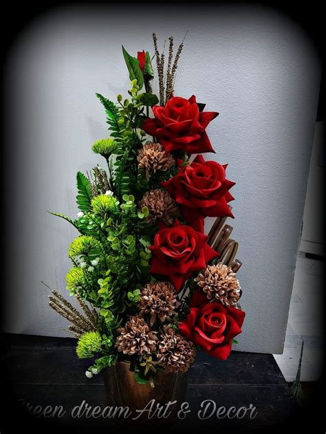 A Vase Filled With Red Roses And Greenery