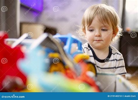 A Huge Bunch Of Different And Colored Toys In Front Of Playful Child