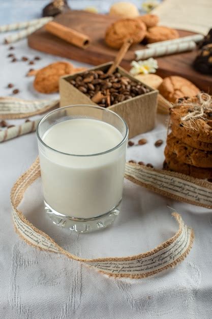 Un Vaso De Leche Con Galletas Alrededor Foto Premium