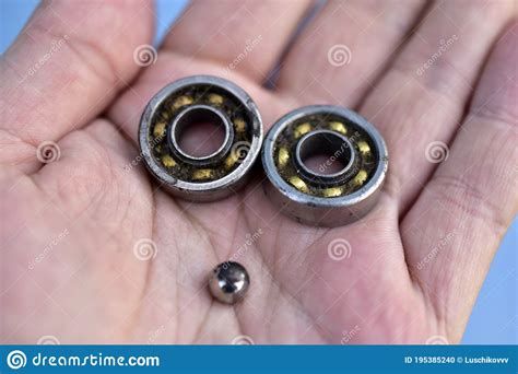 Two Small Ball Bearings in Hand on a Blue Background Stock Photo - Image of macro, clothes ...