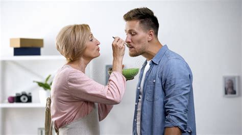 Caring Mother Feeding Adult Son With Spoon Negative Side Of Overprotection Stock Image Image