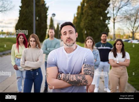 Man Looking Serious At The Camera While Standing In Front Of A Group Of