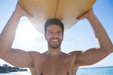 Smiling Shirtless Man Carrying Surfboard At Beach Stock Image Image