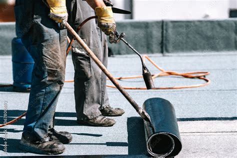 Foto De Construction Workers Roofers Installing Rolls Of Bituminous