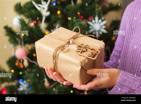 Womans Hands Holding Nice Present Wrapped In Craft Paper Christmas