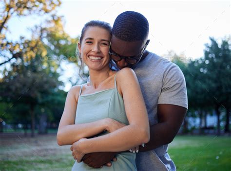 Happy Interracial Couple Hug And Smile For Love Care Or Bonding Together In The Nature Park