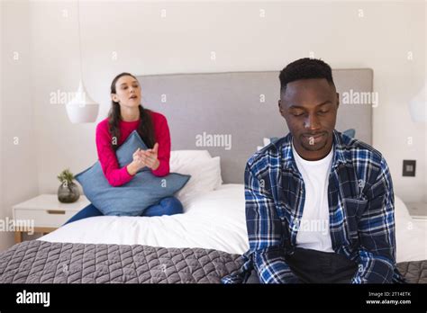 Sad Diverse Couple Sitting On Bed Arguing At Home Lifestyle