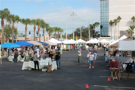 an outdoor market with palm trees in the background