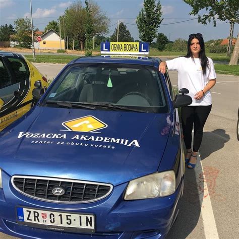 A Woman Standing Next To A Parked Blue Car